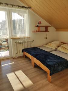 a bedroom with a bed in a room with windows at DG EWA w Polańczyku in Polańczyk