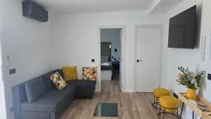 a living room with a blue couch and yellow chairs at Casa TataDora in Arucas