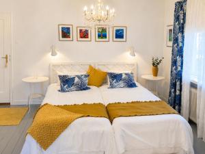 a bedroom with a white bed with blue and yellow pillows at Furuliden Country Inn in Vittsjö +58 photos