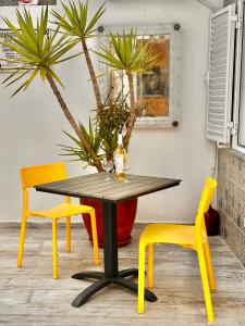 a table and two chairs with a yellow dining room at Patio Suite in Olhão +57 photos