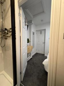 a hallway with a door open to a room with at The Snug Guestroom Poole in Poole +22 photos