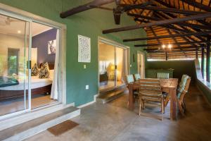 a dining room with a table and a bedroom at Kingfisher Creek Safari Cottages in Hoedspruit
