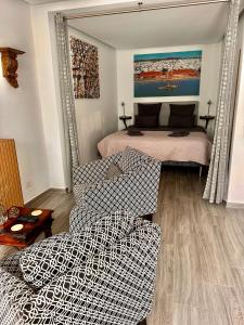 a living room with a bed and two chairs at Patio Suite in Olhão