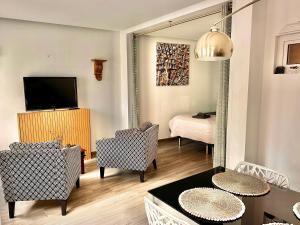 a living room with two chairs and a television at Patio Suite in Olhão