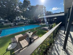 a pool with chairs and a table next to a house at The Zhen in Strand