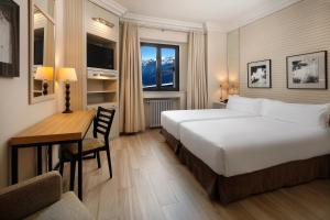 a hotel room with a bed and a desk and a bed and a desk at Parador de Vielha Spa & Wellness in Vielha +67 photos
