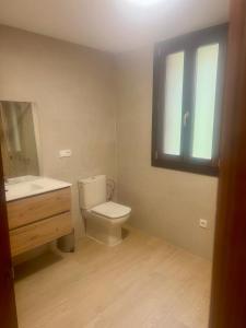 a bathroom with a toilet and a sink and a window at Casa Rural La Escallada in Turanzas +31 photos