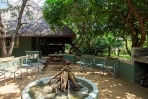 a patio with chairs and a table and a fireplace at Kingfisher Creek Safari Cottages in Hoedspruit