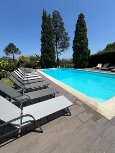 a row of lounge chairs next to a swimming pool at Hotel Rural Solar das Arcadas in Ponte de Lima