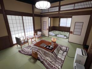 ein Zimmer mit zwei Betten und einem Tisch darin in der Unterkunft 阿蘇扇温泉 おおぎ荘 in Minamioguni