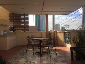 a table and chairs on a balcony with a view at 1 River Central Hostel in Manila