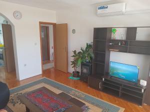 a living room with a flat screen tv and a couch at Guesthouse Behar in Sarajevo