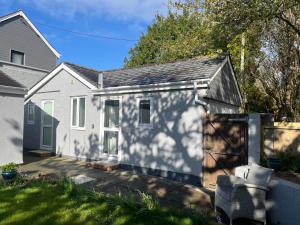 a small white house with a garage in a yard at Silvermead stables Own access studios near Plymouth Life Centre FREE parking in Plymouth