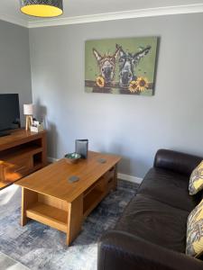 a living room with a couch and a wooden coffee table at Silvermead stables Own access studios near Plymouth Life Centre FREE parking in Plymouth