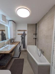 a bathroom with a tub and a sink at Lindo - Historisches Hof-Juwel in Schützen am Gebirge +41 photos