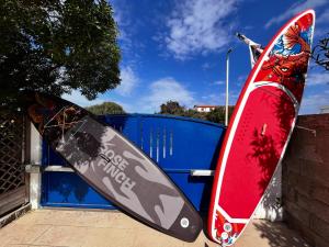 two snowboards are leaning up against a blue fence at B&B Ginepro blu in Portoscuso