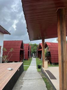 a row of houses with red roofs and a sidewalk at vila La-surf in Padangnegeri