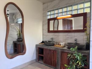 a bathroom with two sinks and a mirror at Gumi Ayu EcoStay in Munduk
