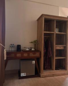 a wooden cabinet with a desk in a room at Gumi Ayu EcoStay in Munduk