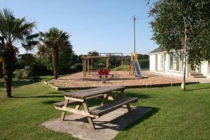 einen Park mit einer Bank und einem Spielplatz in der Unterkunft Ivy Tower Cottages in Saint Florence