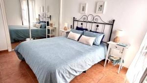 a bedroom with a large bed with a blue comforter at Vitamin Sea in Zahara de los Atunes