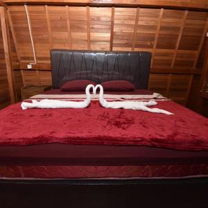 a close up of a bed with a red blanket at vila La-surf in Padangnegeri