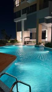 a swimming pool in front of a building at night at Luxury Trizen Aki Apartments in Colombo