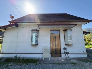 a small white house with a sign in front of it at Retreat 舞月 in Tanabe