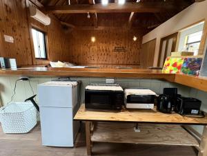 a kitchen with a table with two microwaves on it at Retreat 舞月 in Tanabe