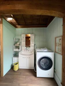 a laundry room with a washing machine and a sink at Retreat 舞月 in Tanabe