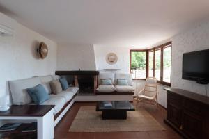 a living room with a white couch and a tv at Villa Fornaci - Marina di Campo in Marina di Campo