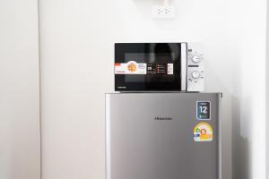 a microwave sitting on top of a refrigerator at Palai House in Ban Na Bon