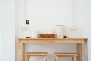 a wooden table with two stools and a coffee maker at Palai House in Ban Na Bon