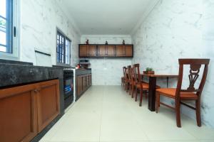 a kitchen with a table and chairs in a room at Villa les 3 oisillons in Kribi