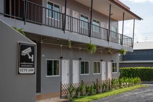 a building with white doors and plants in front of it at Palai House in Ban Na Bon