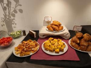 a table topped with plates of food and pastries at venice blu hotel in Mirano