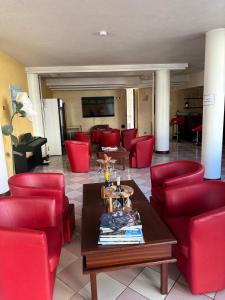 a living room with red chairs and a table at venice blu hotel in Mirano