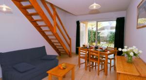 a living room with a blue couch and a table at Lagrange Vacances - Les Hameaux de l'Océan in Carcans