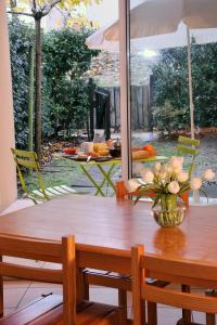 a wooden table with a vase of flowers on it at Lagrange Vacances - Les Hameaux de l'Océan in Carcans