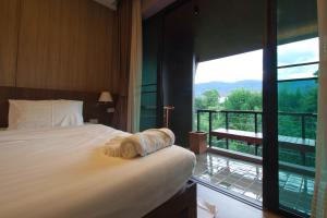 a bedroom with a bed and a balcony with a view at Burapa Boutique in Chiang Mai