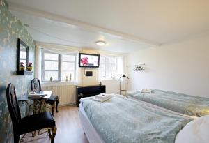ein Hotelzimmer mit 2 Betten, einem Tisch und einem Schreibtisch in der Unterkunft Myregaard B & B and Apartments in Snogebæk