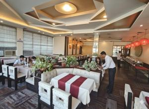 a group of people sitting at tables in a restaurant at Hotel Asia Vaishnodevi Katra in Katra