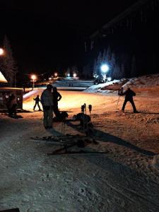 un gruppo di persone con sci nella neve di notte di Horska Chata Nejdecka a Pernink