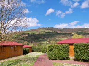 a house with a red roof with a mountain in the background at Albergue Finca El Mazo in Rada
