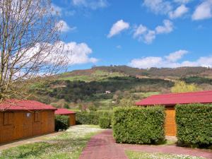 una casa con techo rojo con una montaña en el fondo en Albergue Finca El Mazo, en Rada