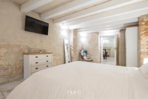 a bedroom with a bed and a tv on the wall at Castello Room & Spa in Cagliari