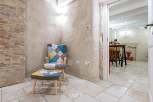a living room with a chair and a table at Castello Room & Spa in Cagliari