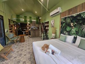 a bedroom with a bed with a doll laying on it at Three Hen Lakeside in Ban Na Nai