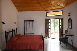 een slaapkamer met een bed en een houten plafond bij Maskeli Oya Family Park in Norton Bridge