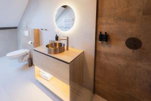 a bathroom with a sink and a toilet and a mirror at Maison Kounic Palace Suites in Slavkov u Brna +207 photos